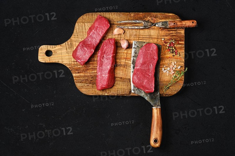 Top view of raw boneless strip steak on black background