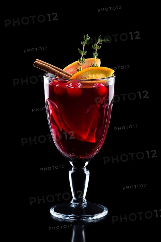 Glass of hot mulled wine isolated on black.