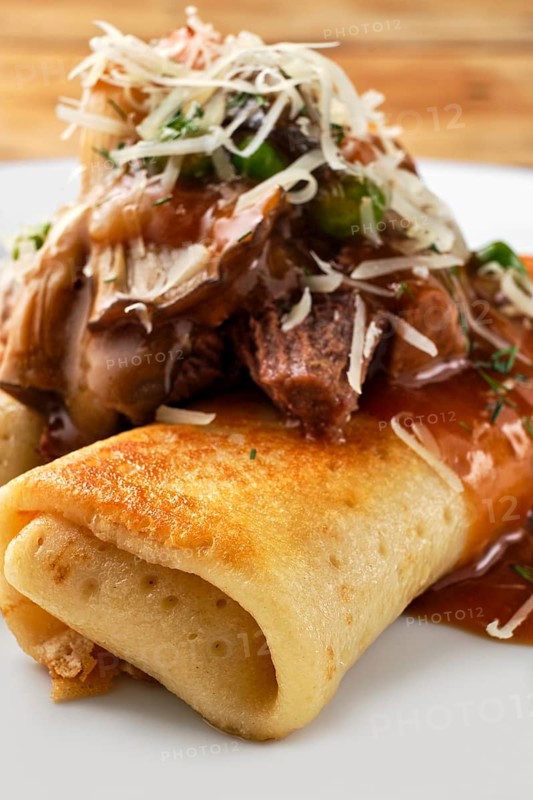 Macro photo of thin pancakes stuffed with beef and mushrooms