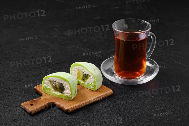 Sweet dessert mochi with kiwi cut on half and fruit tea