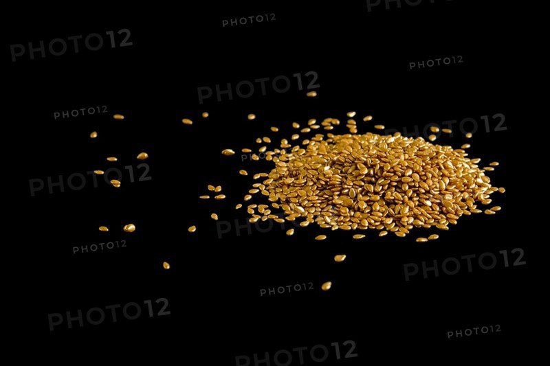 Pile of gold plated sesame seeds on black background