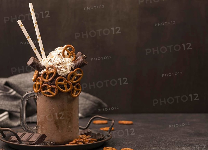 Front view chocolate milkshake with straws pretzels