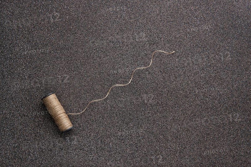 Top view of untwisted linen twine on dark stone background