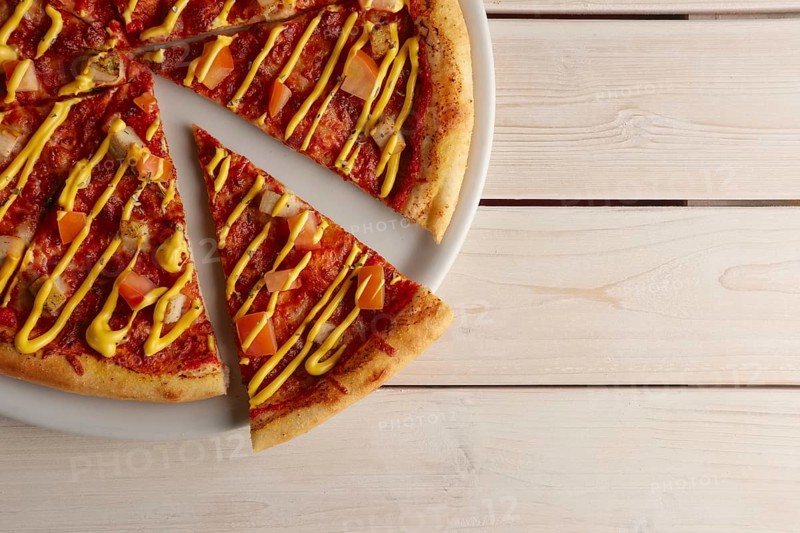 Top view of pizza with sun-dried tomatoes and mustard sauce
