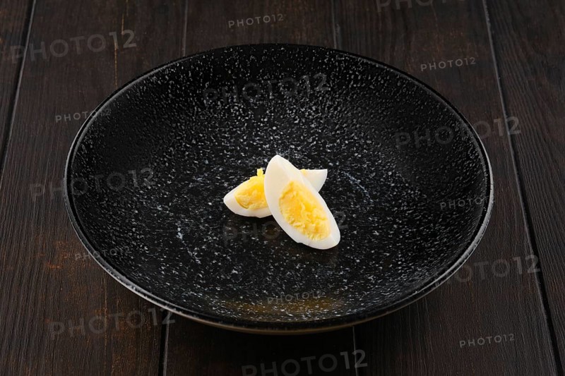 Half of boiled egg cut on two pieces on a plate