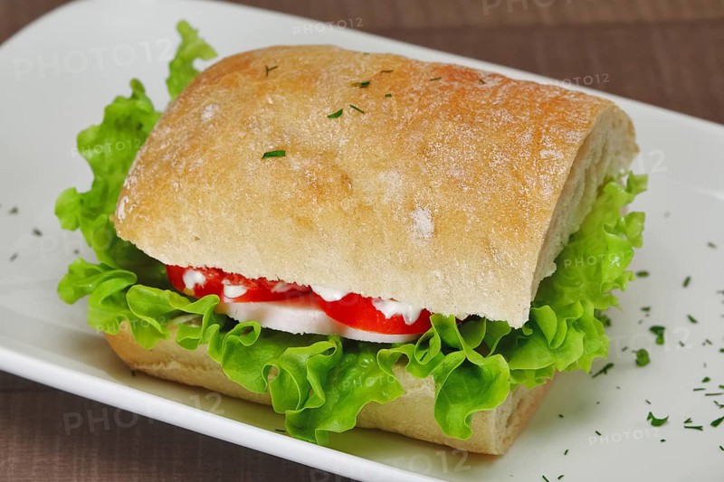 Ciabatta panini sandwich with chicken and tomato. Sandwich stuffed with sausage