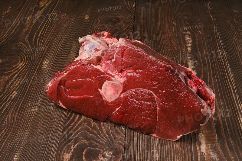 Raw fresh beef shank cross-cut on wooden background