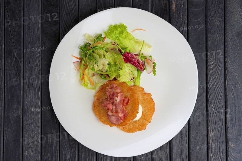 Traditional russian draniki with bacon and salad. Top view