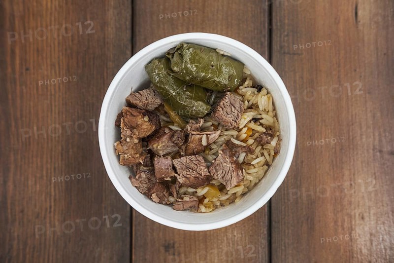 Soft focus photo of dolma and fried meat in take away plate