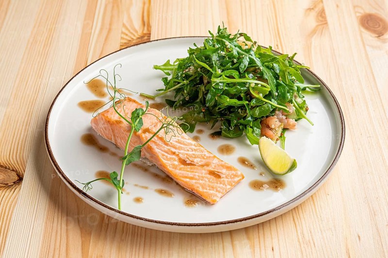 Steamed salmon with arugula and shrimps garnish