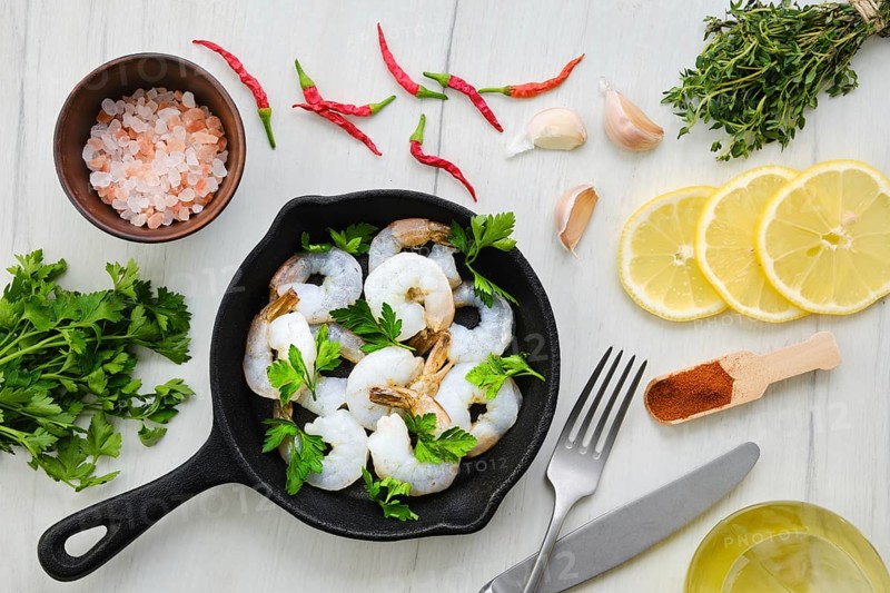 Top view of pan with fresh raw prawn with spice and herbs