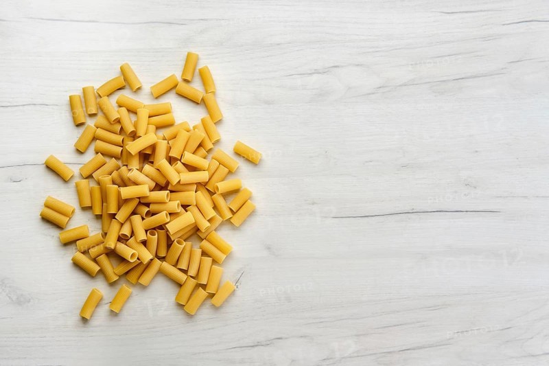 Overhead view of rigatoni pasta on wooden table