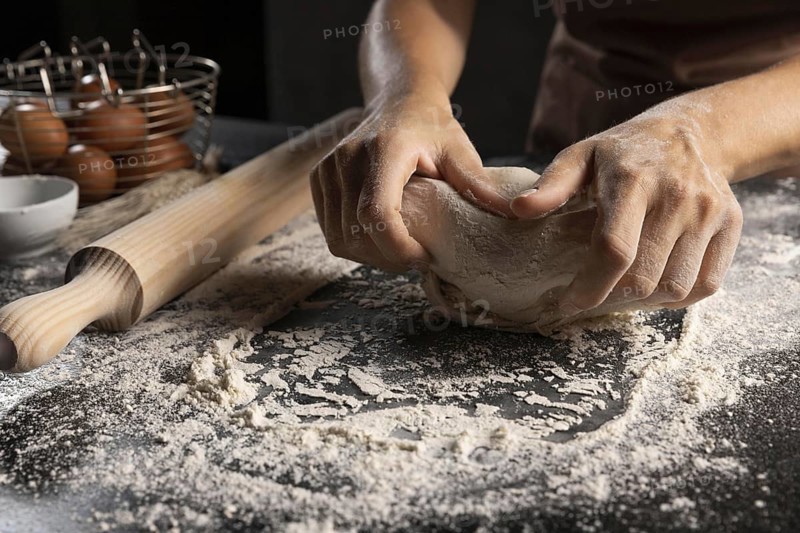 Chef kneading dough flour table