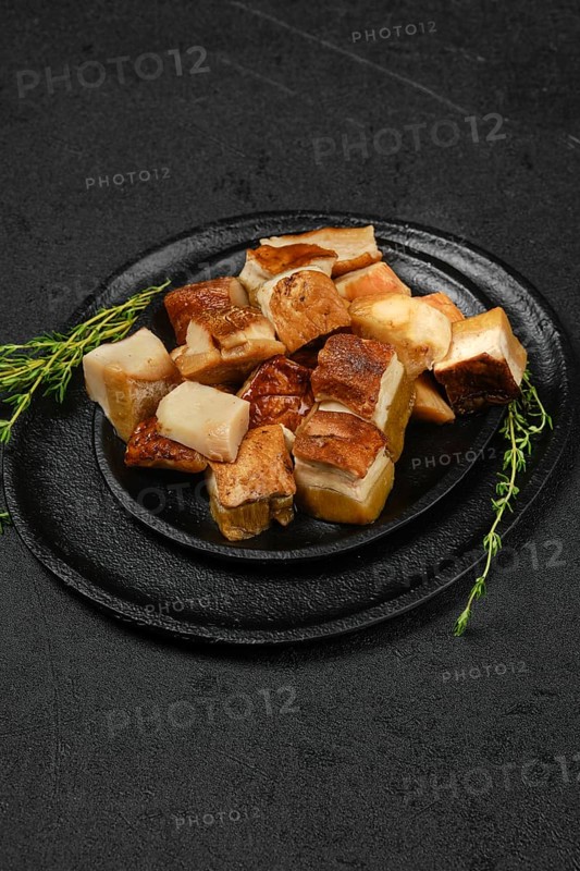 Frozen fresh boletus cut on pieces on black stone plate