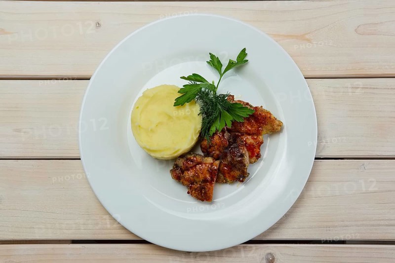 Portion of delicious fried meat in honey sauce with mashed potato. Top view