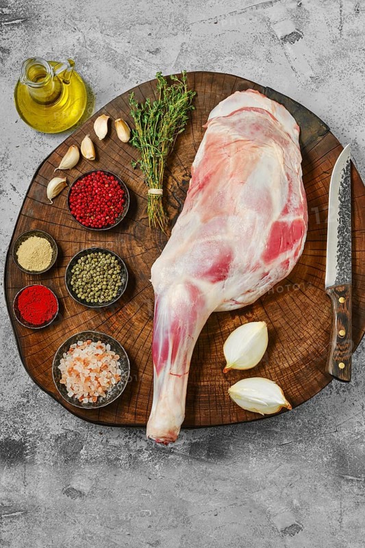 Raw lamb shoulder chump on butcher's cutting log