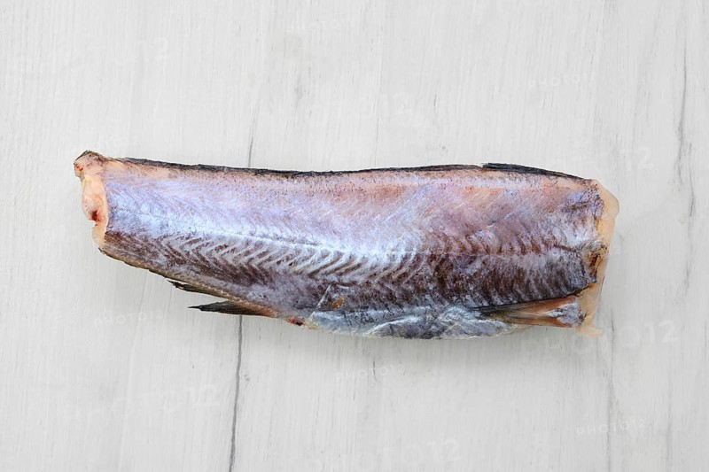 Frozen raw pollock carcass on wooden background