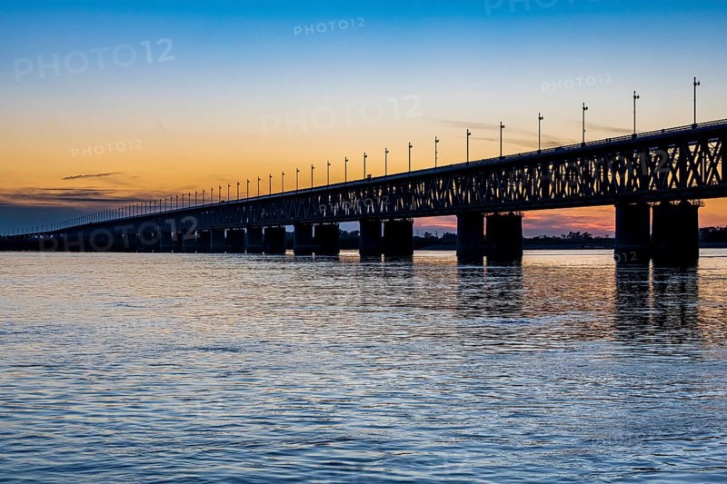 Giant bridge spanning over the Amur river at sunset