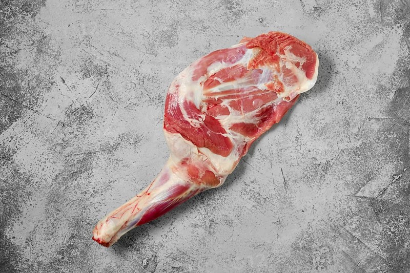 Raw lamb shoulder chump on on shabby grey background