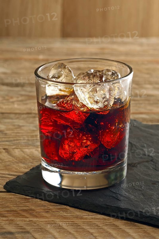 Rum and cola cocktail on wooden background