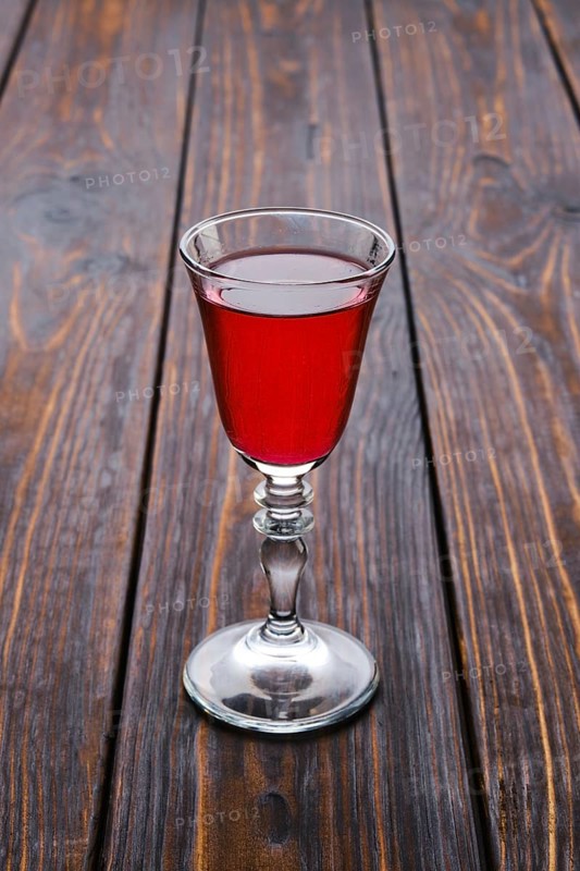 Vodka infused with berries on wooden background