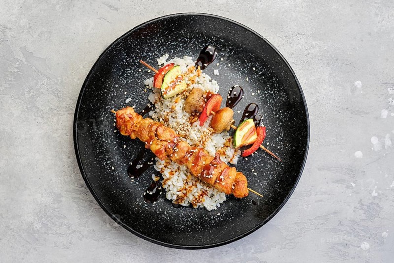 Top view of shashlik with chicken and grilled champignon with bell pepper and zucchini served with boiled rice