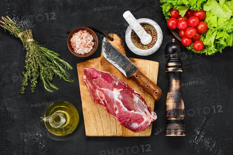 Overhead view of raw lamb rump on wooden cutting board