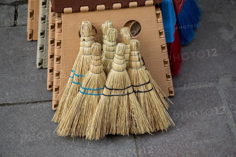 Set of yellow straw broom in a bazaar