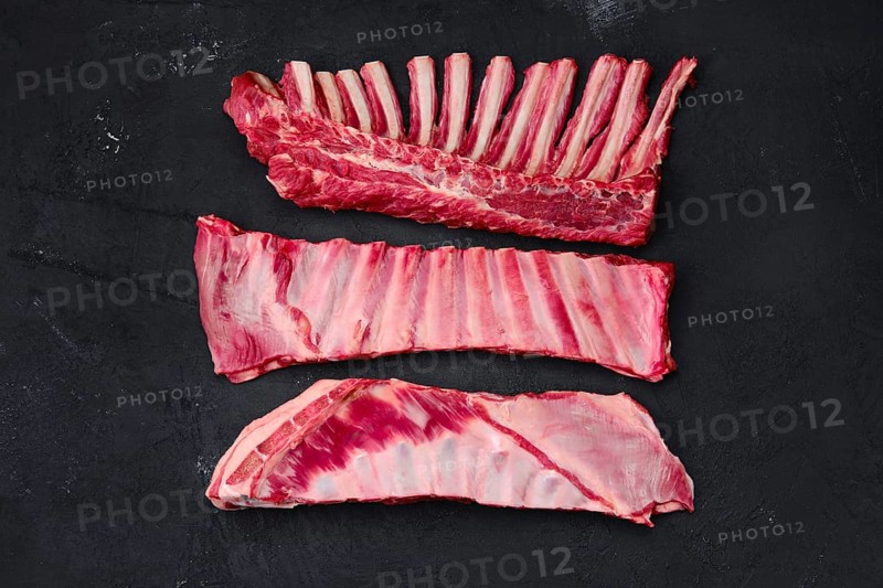 Assortment of fresh raw lamb cuts on dark background