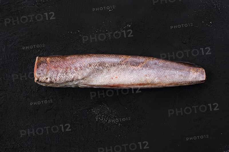 Raw frozen hake on black background