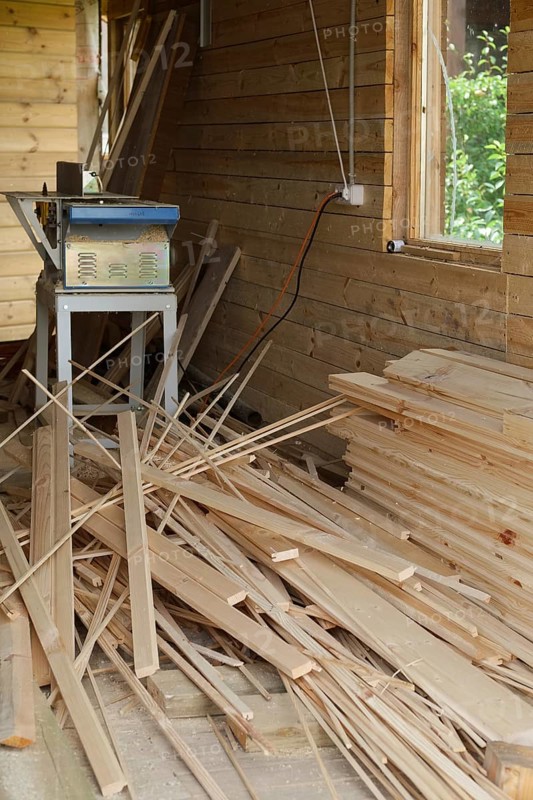 Joinery with electrick saw and pile of planks scattered on the floor