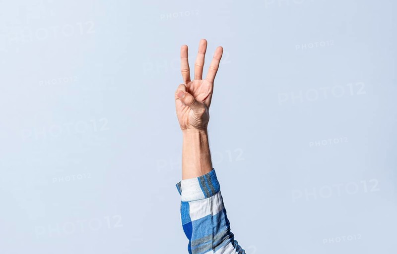 Hand gesturing the letter W in sign language on an isolated background. Man's hand gesturing the letter W of the alphabet isolated. Letter W of the alphabet in sign language