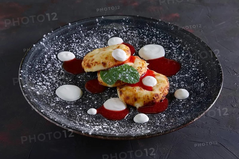 Cheese pancakes with sour cream and strawberry jam