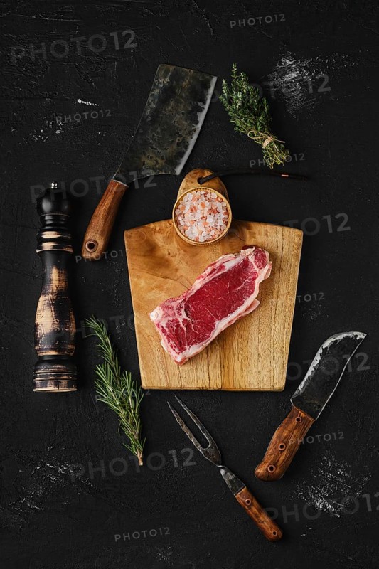 Top view of raw strip steak boneless on dark background