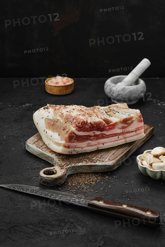Salted with caraway pork belly lard on cutting board