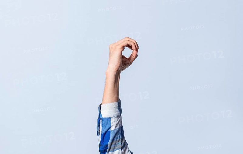 Hand gesturing the letter O in sign language on an isolated background. Man's hand gesturing the letter O of the alphabet isolated. Letter O of the alphabet in sign language