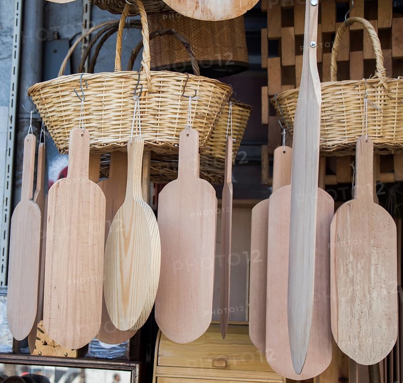 Wooden chopping boards and straw baskets hanging on display