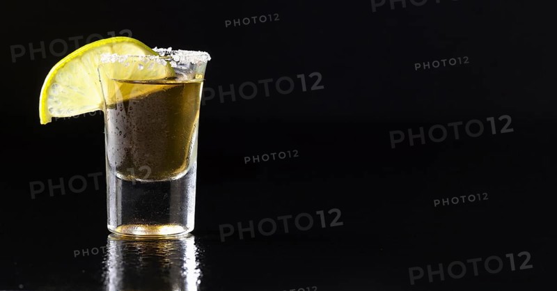 Front view gold tequila shot with lime copy space
