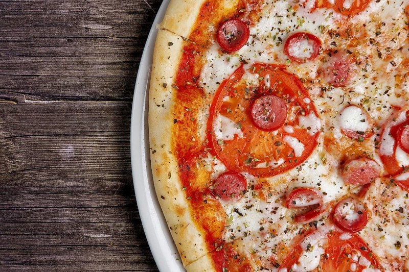 Part of pepperoni pizza on wooden table