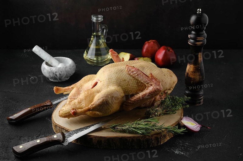 Raw whole country duck on wooden cutting board