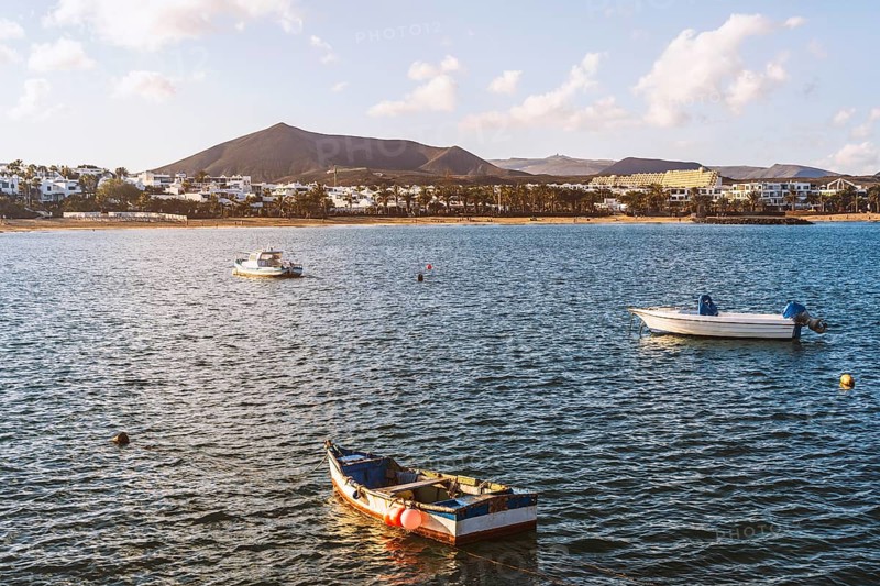 View of the resort town named Costa Teguise with boats on the foreground