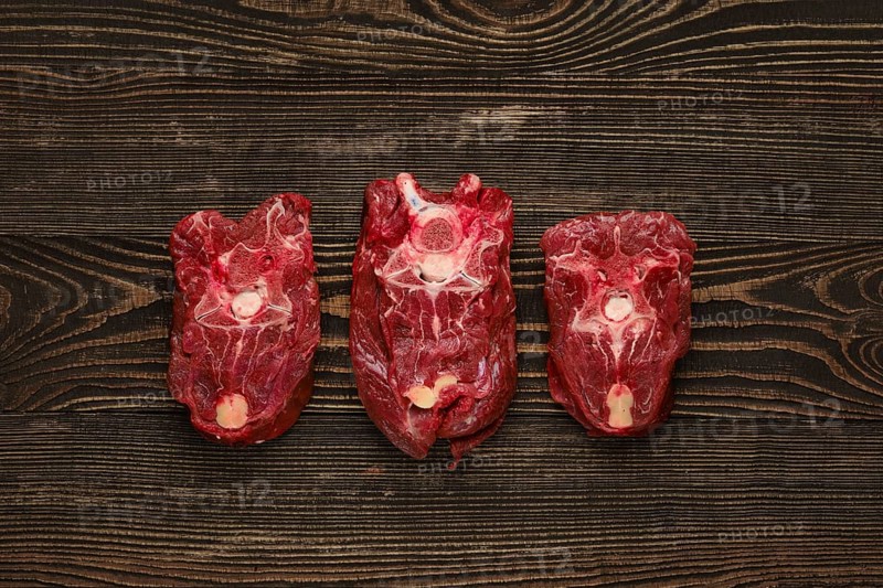 Overhead view of raw fresh deer neck over dark wooden background