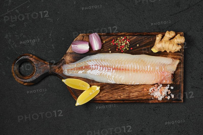 Top view of freshly frozen zander fillet on wooden cutting board