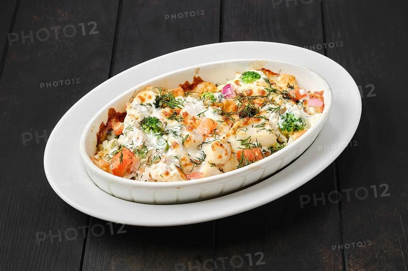 Potato and ham casserole baked in oven with cheese and vegetables