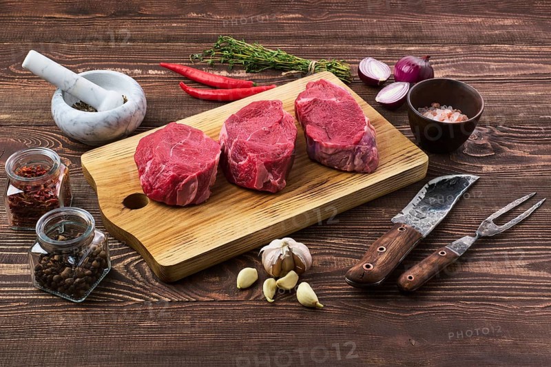 Marinated raw beef steak with spice on wooden table