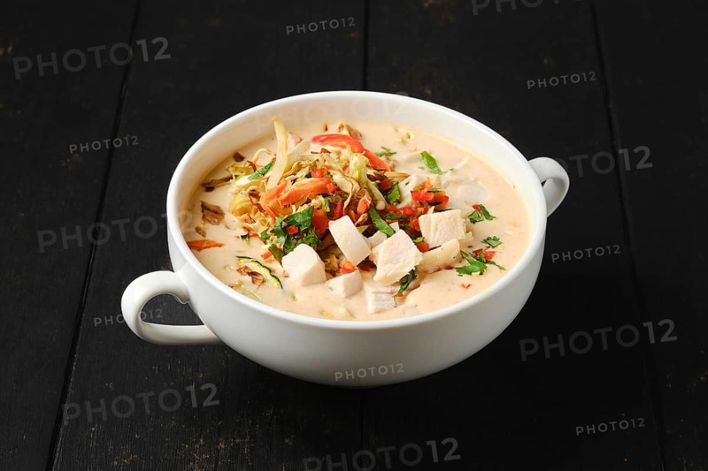 Creamy chicken soup puree with fried carrot and onion