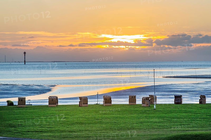Grassy beach with beach chairs at sunset on the Wadden Sea at the mouth of the Weser