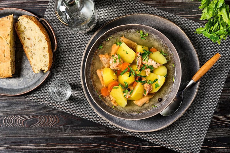 Top view of red salmon fish soup with potato and carrot