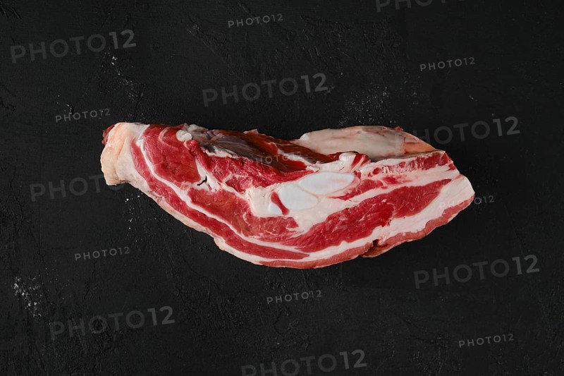 Overhead view of raw beef brisket on wooden cutting board