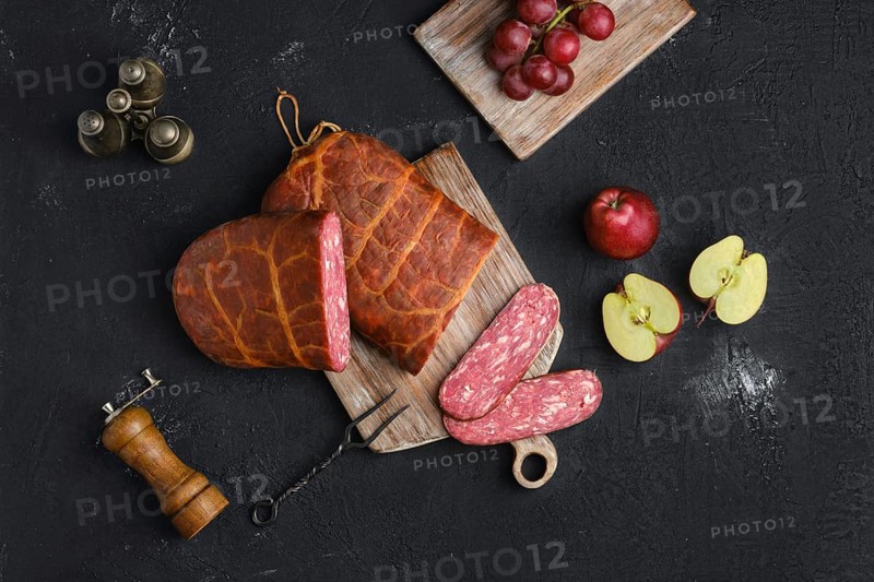 Homemade smoked beef sausage in organic casing on wooden cutting board